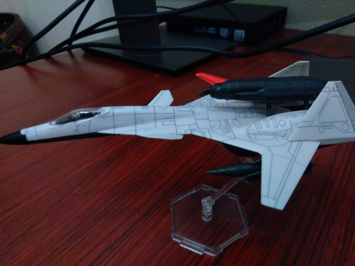 A model kit of a 1/144 ADFX-01 from Ace Combat Zero sitting on a desk. The photo is taken from a top down view showing expansive panel lining.